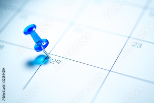 Blue push pin on calendar 29th leap year day of the month