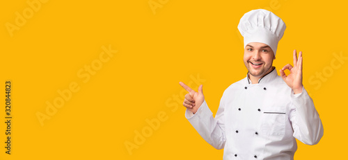 Chef Gesturing Okay Pointing Finger At Copy Space, Yellow Background