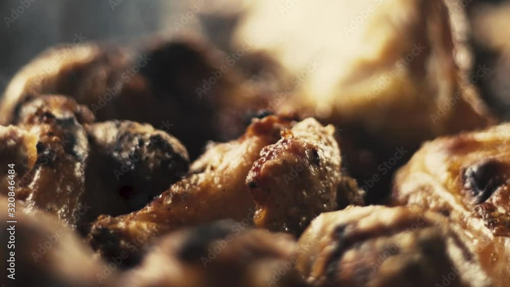 Slow motion close-up shot of chicken wings and smoke from the charcoal grill Slow motion close-up shot of chicken wings and smoke from the charcoal grill