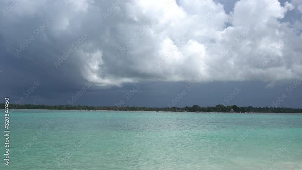 Panning shot of an idyllic tropical beach in Indonesia on a cloudy day.