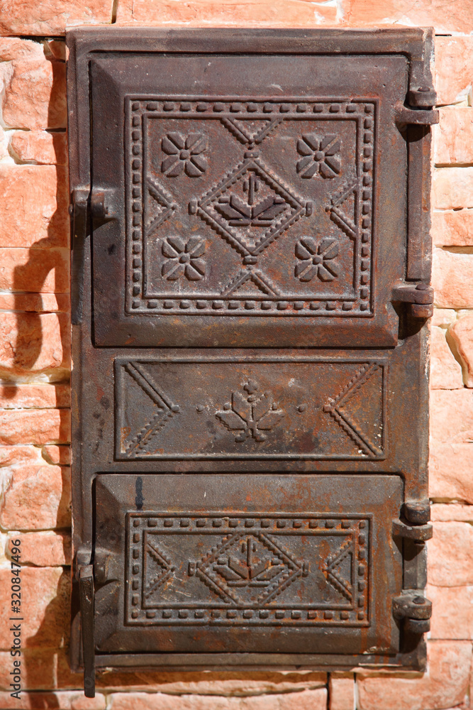 Wrought iron door of the stove with a national Ukrainian ornament. Iron door of the stove. Two old furnace doors. Ancient stove. Cast iron door for furnaces. Iron door ornament.