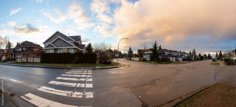 Residential Suburban Neighborhood in the City during a vibrant winter sunset. Taken in Fraser Heights, Surrey, Vancouver, BC, Canada. Panorama, Wide Angle Residential Suburban Neighborhood in the City during a vibrant winter sunset. Taken in Fraser Heights, Surrey, Vancouver, BC, Canada. Panorama, Wide Angle