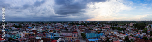 Ciego de Avila, Cuba - June 14, 2019: Aerial Panoramic view of a small Cuban Town during a cloudy and colorful sunset. © edb3_16