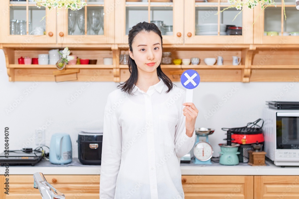 バツのプラカードを持つ女性