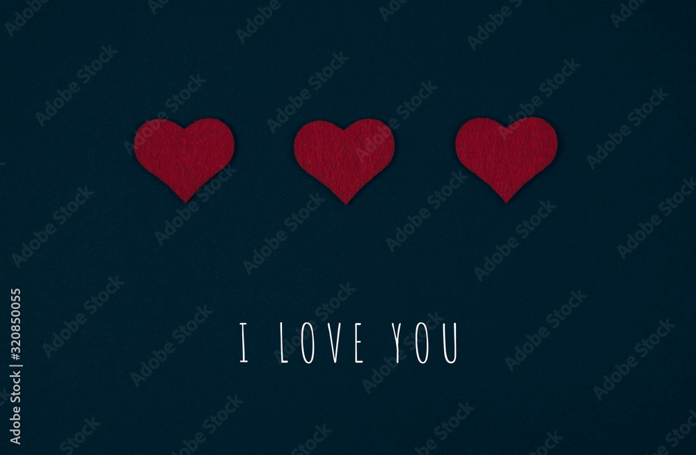 Greeting or invitation card with red hearts over black background with inscription I love you. Top view. Valentines day card. Greeting or invitation card with red hearts over black background with inscription I love you. Top view. Valentines day card.