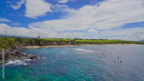 Wallpaper Mural Surfers waiting for wind to create big waves on isolated bay with blue turquoise seawater surrounded by rocky shoreline in Hawaii Torontodigital.ca