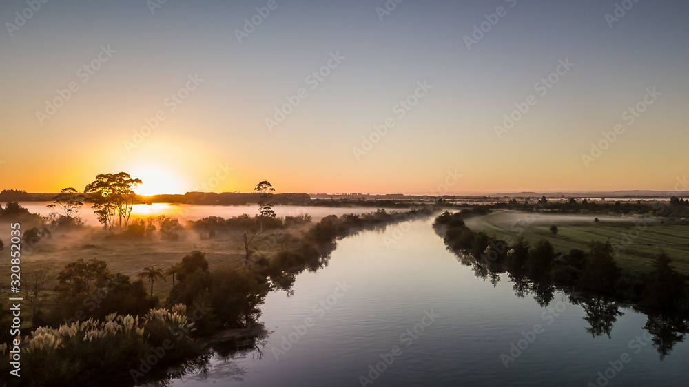 Aerial view on a calm river reflection during sunrise