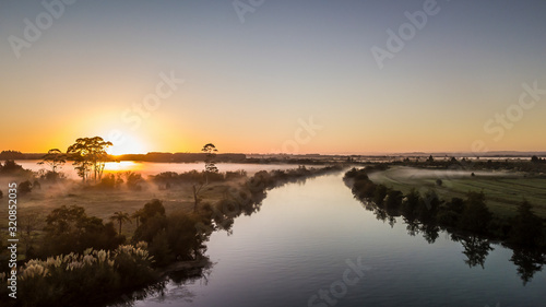 Aerial view on a calm river reflection during sunrise