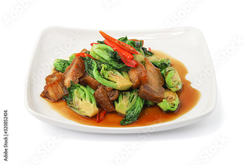 Stir fried Chinese broccoli with Crispy Pork isolated on white background with clipping path, Stir Fried Crispy Pork with Kale, Thai food.