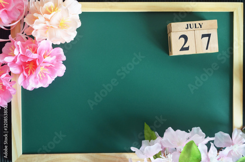 July 27, Japanese Cover, Number cube of date with sakura flower on the wood green board.