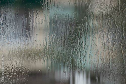 Rainy weather, raindrops on the glass of window, water drips wet. Texture, background.