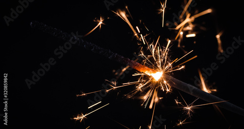 Firework festive sparkler burning on black background