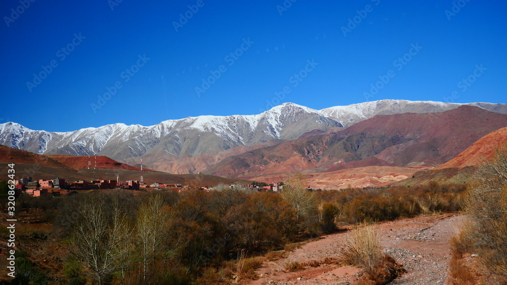 Fototapeta premium Bright landscape of Morocco, breathtaking curves of mountains, stunning combination of hills & farm land,inadvertent distribution of houses & huts, raw impression of pure nature.
