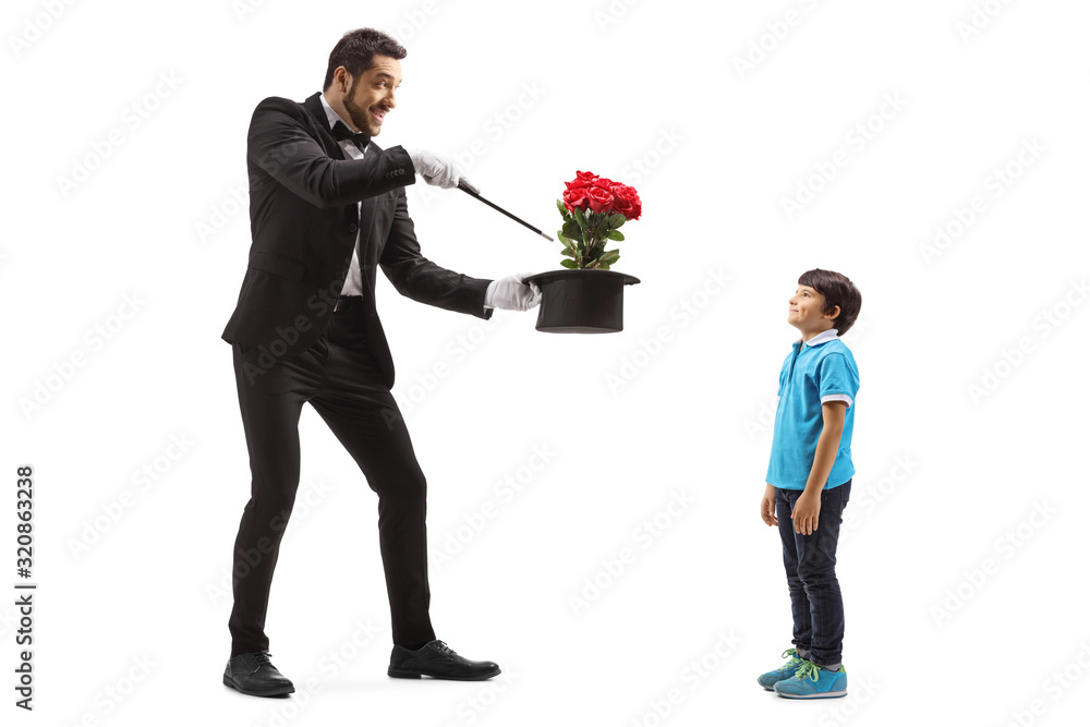 Magician making a hat trick with flowers in front of a boy Magician making a hat trick with flowers in front of a boy