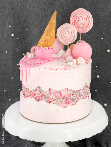 Faultline Drip Cake Buttercreme Torte Kuchen mit pinken Zuckerstreusel Eis Lollipops Kugeln photo