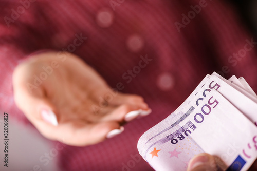 Woman holding euro currency in her hands. Hand giving paper euros or money.