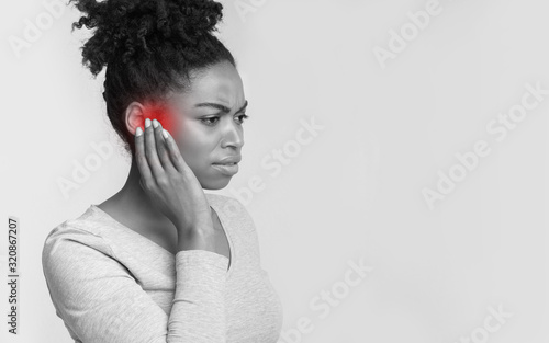 Sick afro woman having pain in ear photo