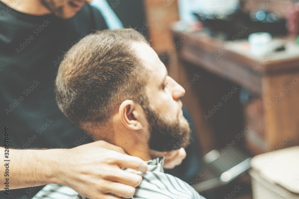 Haircut at the hairdresser. Barber cuts the hair on the client's head. The process of creating hairstyles for men. A man in a barbershop. The near plan. Equipment stylist. Selective focus Haircut at the hairdresser. Barber cuts the hair on the client's head. The process of creating hairstyles for men. A man in a barbershop. The near plan. Equipment stylist. Selective focus