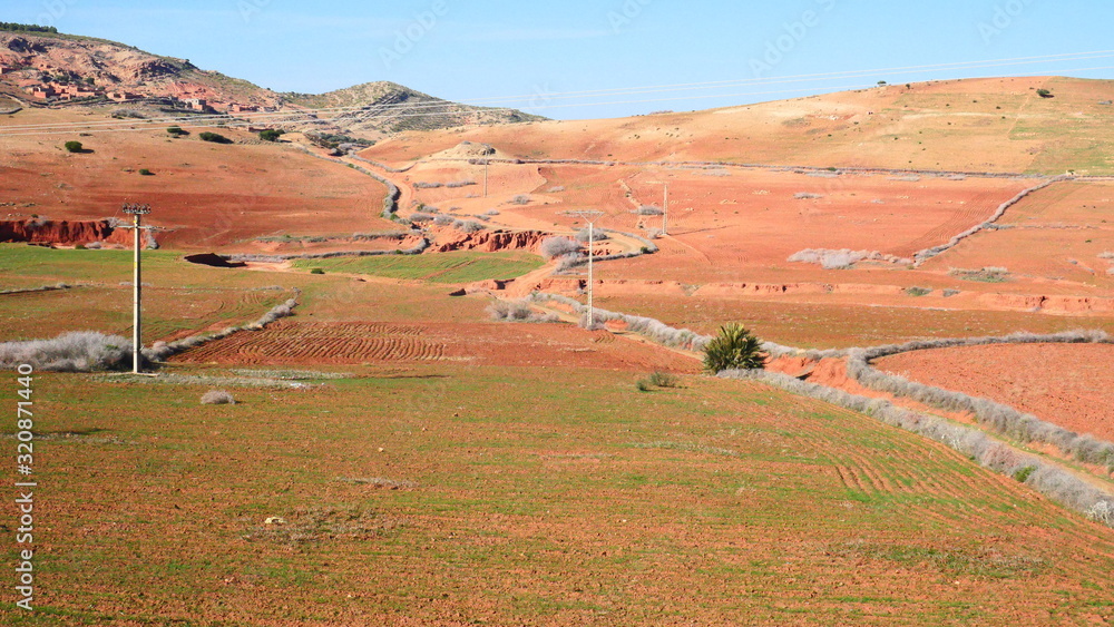 Obraz premium Bright landscape of Morocco, breathtaking curves of mountains, stunning combination of hills & farm land,inadvertent distribution of houses & huts, raw impression of pure nature.