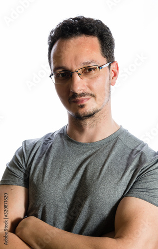 Head shot portrait of young, muscular man in gray t-shirt, studio shot on white background.