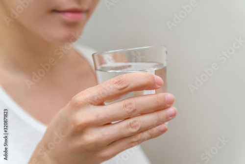 healthy beautiful young woman holding a glass of water. clean drinking water in a clear glass in your hands