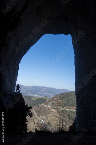 man inside a cave in basque country, spain © urdialex