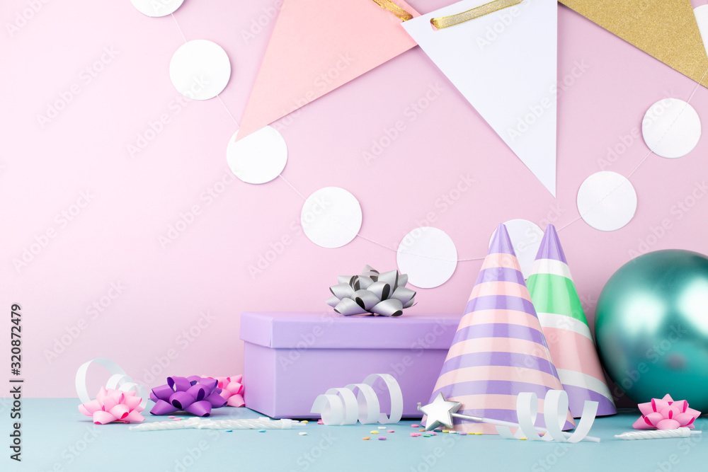 Happy Birthday concept. Blue table with gift, balloons and other decorations on pink wall background. 