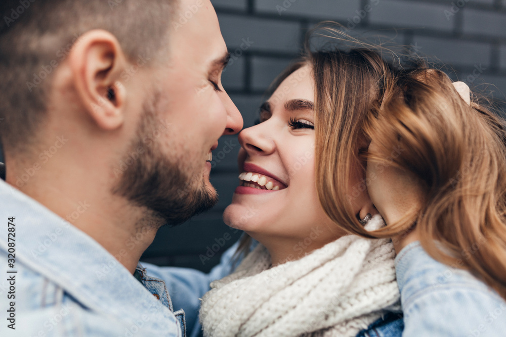 Close-up shot of smiling bearded man touching girlfriend's hair. Outdoor portrait of romantic laughing woman enjoying date. Close-up shot of smiling bearded man touching girlfriend's hair. Outdoor portrait of romantic laughing woman enjoying date.