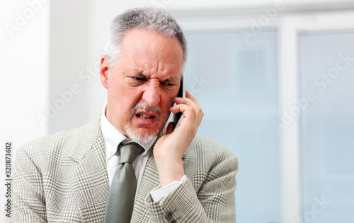 Portrait of an angry businessman yelling at phone