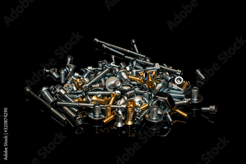 A bunch of different bronze and steel screws, bolts and nuts © Sergey