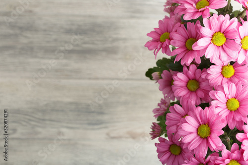Pink flowers, over wood background.