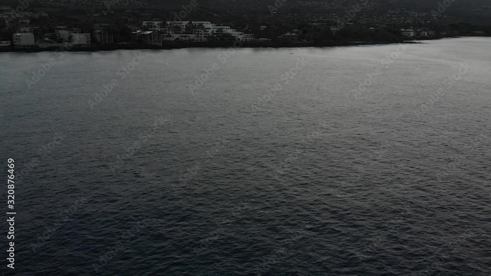 Aerial shot of calm kona ocean before dawn looking at mountain and hotels Aerial shot of calm kona ocean before dawn looking at mountain and hotels