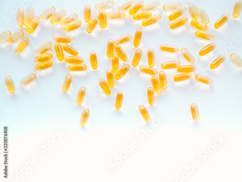 Yellow pills with Omega 3. Macro vertical photo.