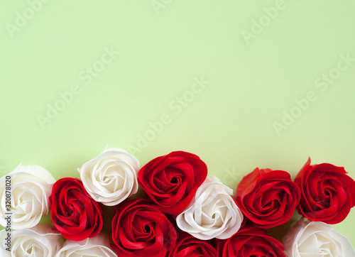 Red and white roses on a green background. Festive background for Valentine s day