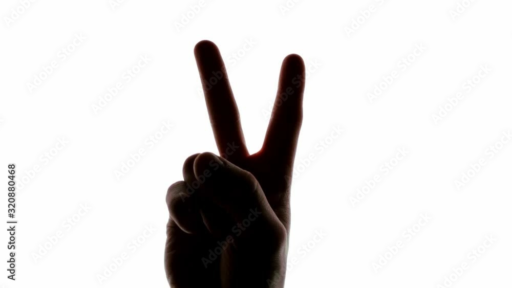 Backlit silhouette of a hand holding up two fingers in the symbol of peace before descending out of shot Backlit silhouette of a hand holding up two fingers in the symbol of peace before descending out of shot