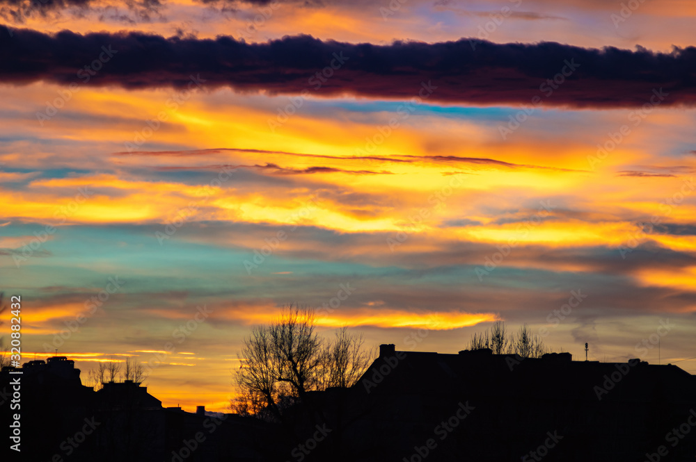 Colorful sunset sky over the houses of the city