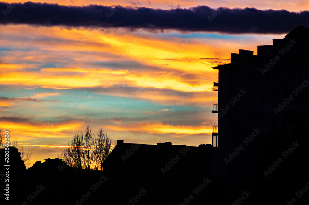 Colorful sunset sky over the houses of the city