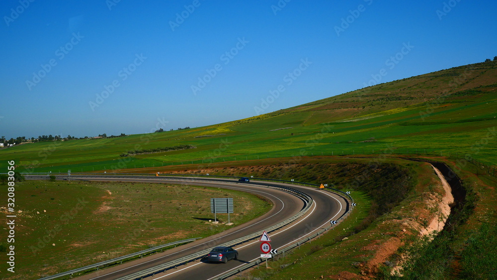 Bright landscape of Morocco, breathtaking curves of mountains, stunning combination of hills & farm land,inadvertent distribution of houses & huts, raw impression of pure nature.