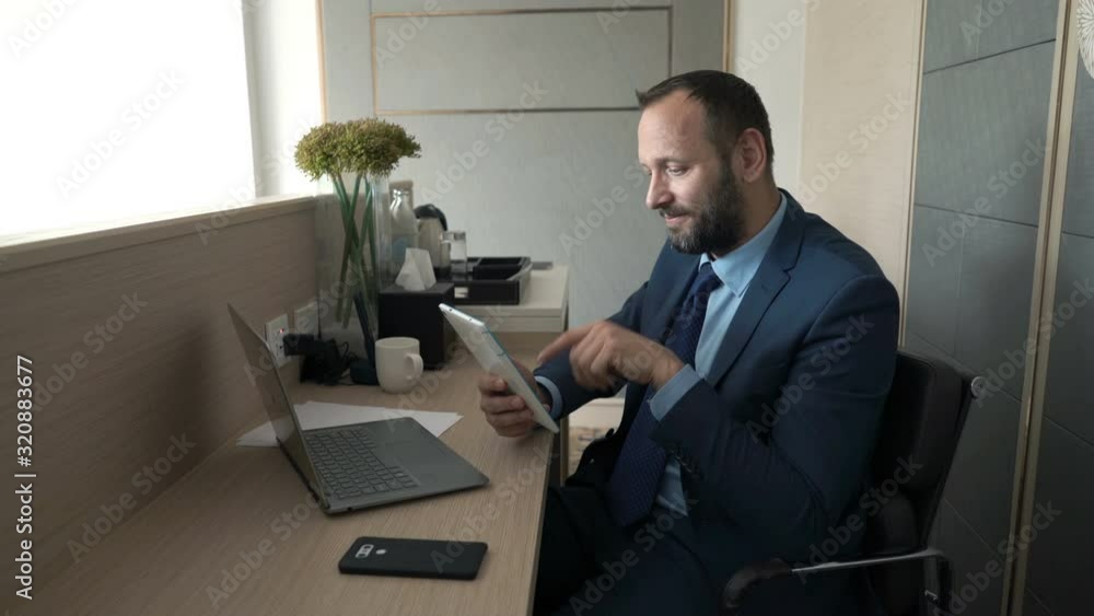 Young businessman working on tablet computer in the office