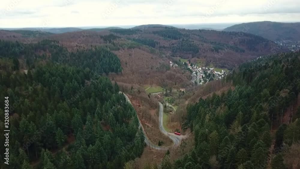 Aerial zoom out view of road curving through valley between mountains in Peterstal, Germany. Aerial zoom out view of road curving through valley between mountains in Peterstal, Germany.