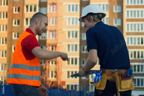 Two builders at construction site fooling around