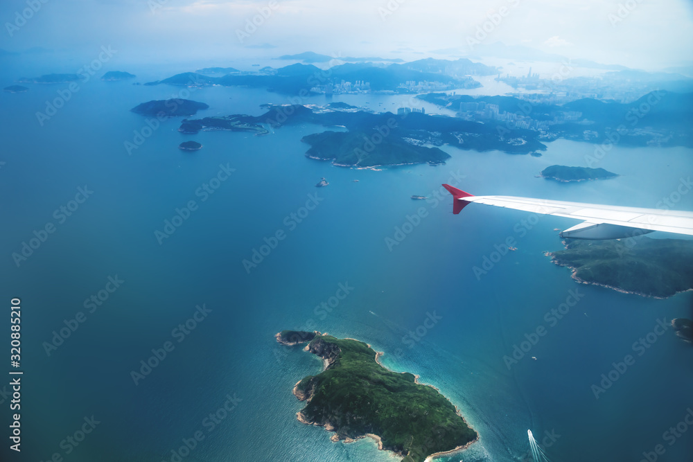 Aerial view of Hong Kong islands from a flying airplane with wing
