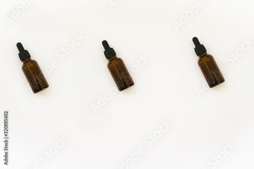 Homemade cosmetics glass bottles pattern. Natural medicine concept. Jars with essential oil isolated on a white background. Flat lay or top view.