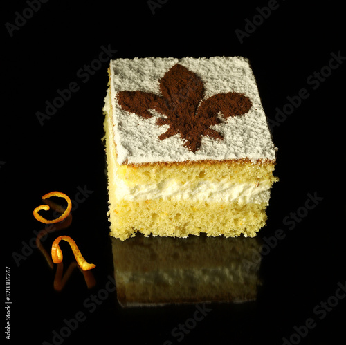 l concetto di cibo italiano. Primo piano di schiacciata fiorentina, una torta di carnevale di Firenze con crema e aroma di arancia. Giglio fiorentino sulla torta cosparso di cacao in polvere. photo