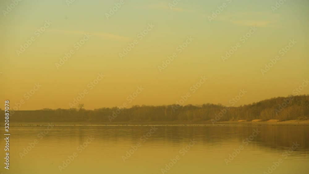 Calm and peaceful view of a lake during a yellow sunset Calm and peaceful view of a lake during a yellow sunset
