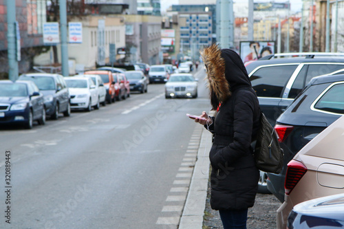 Illustration of the problem of the modern age. Called digital zombie. People are watching their smart phone with hood and headphones and don´t pay attention on the traffic. 
