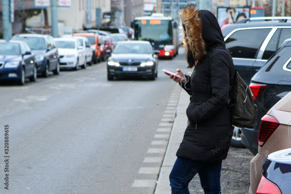Illustration of the problem of the modern age. Called digital zombie. People are watching their smart phone with hood and headphones and don´t pay attention on the traffic. 