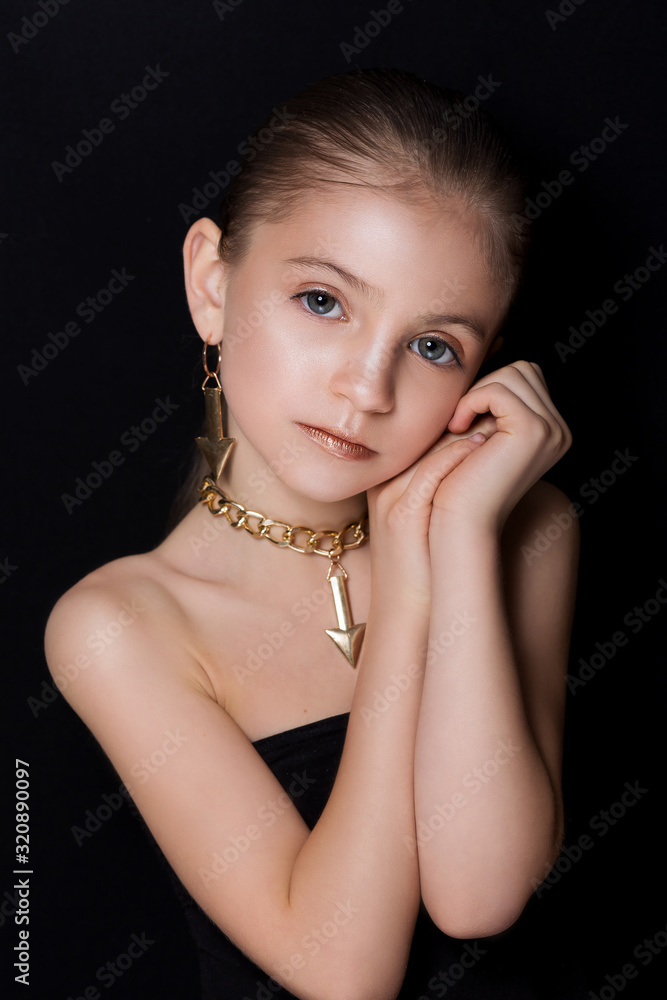 Obraz premium Closeup portrait of glamour little girl with beautiful visage. The beautiful girl on a black background.