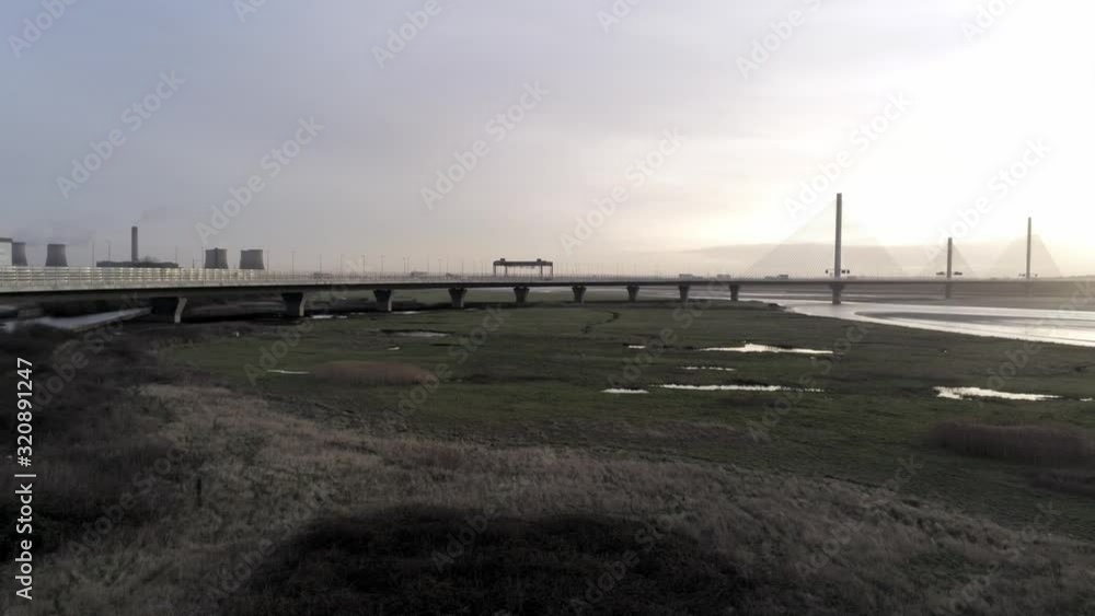 Aerial view of traffic vehicles on Mersey gateway motorway landmark Runcorn skyline bridge crossing. Low pan right. Aerial view of traffic vehicles on Mersey gateway motorway landmark Runcorn skyline bridge crossing. Low pan right.