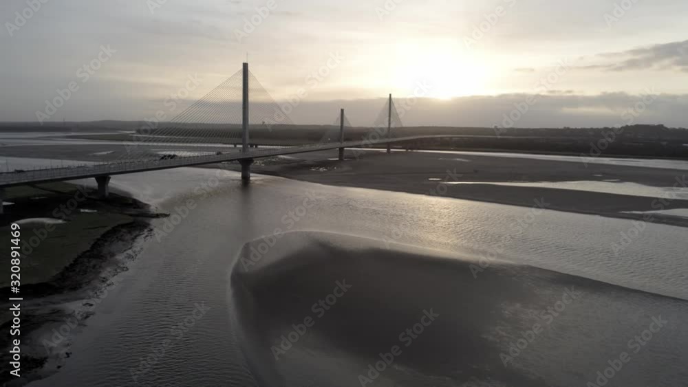 Aerial pause & push in view above River Mersey Gateway suspension bridge at sunrise. Aerial pause & push in view above River Mersey Gateway suspension bridge at sunrise.